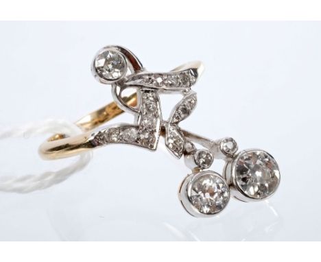 Unusual antique diamond ring with a stylised floral spray with three principal old cut diamonds and further old cut diamond t