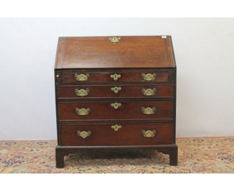 George III oak bureau, the hinged fall enclosing a fitted interior with four graduated drawers, on bracket feet, 93cm wide x 