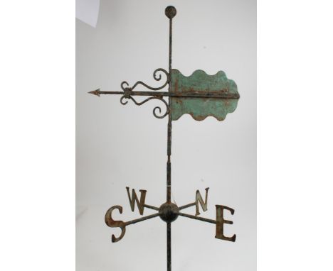 Antique green painted cast iron weather vane of traditional form, with scrollwork pointer revolving on cruciform compass poin