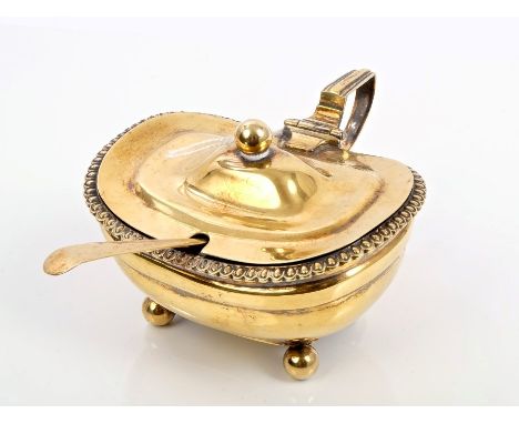 Late Victorian silver gilt mustard pot of compressed cauldron form, with ovular border, rear mounted handle and domed hinged 