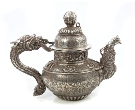 Interesting Tibetan silver teapot of small proportions, with chased and engraved foliate decoration, the spout in the form of