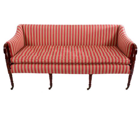 Regency mahogany sofa with square upholstered back, raised on turned fluted supports terminating on brass cappings and castor