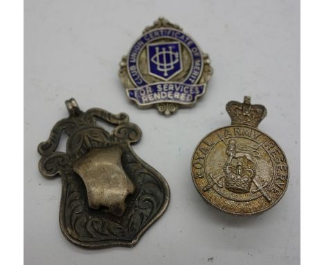 A silver fob and two silver badges, one marked Royal Army Reserve, weight 18g
