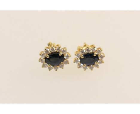 Pair of sapphire and diamond cluster earrings, the oval cut sapphires totalling approx. 1.54cts, bordered with tiny brilliant