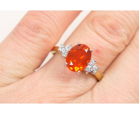 Fire opal and diamond cluster ring, the oval cut opal of approx. 2cts, oval cut and set in a four claw 18ct white gold mount,