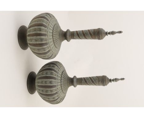 Pair of Indian metal bottle vases, early 20th Century, wide baluster form with a slender neck, worked with panels of scrollin