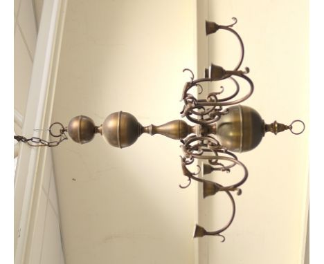 Dutch style brass chandelier, with a central ball and baluster column, supporting six S-shaped branches issuing from dolphin 