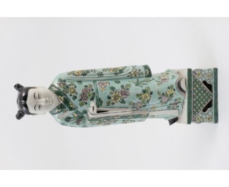 Chinese famille verte figure of an attendant, Kangxi (1662-1722), decorated throughout with flowers and fruits in colours wit
