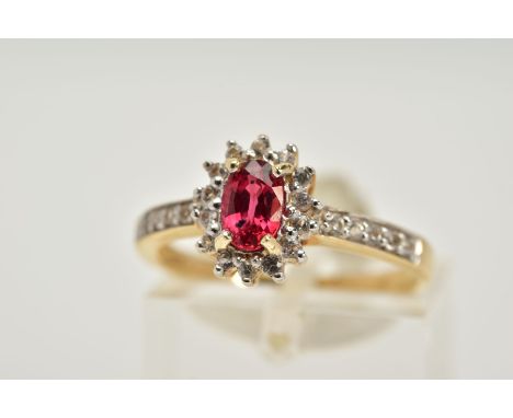 A 9CT GOLD RUBY AND SAPPHIRE CLUSTER RING, designed with a central oval cut ruby within a circular cut colourless sapphire su