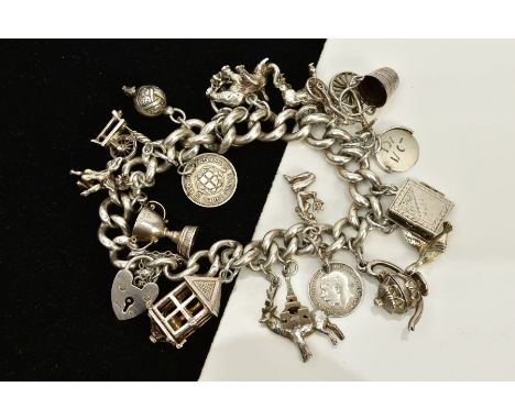 A SILVER CHARM BRACELET, suspending nineteen charms, such as a lamp, winners cup, book, teapot, flying duck, bucket, cupid, e