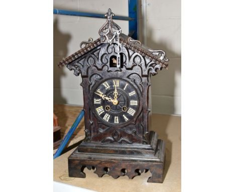 A BLACK FOREST STYLE CUCKOO MANTLE CLOCK, having Roman numerals, standing 48cm high including finial, back screwed shut, runs