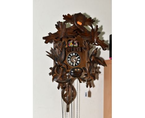 A MID TWENTIETH CENTURY BLACK FOREST STYLE CUCKOO CLOCK, with matched pediment and pendulum, with dancing figures above the p