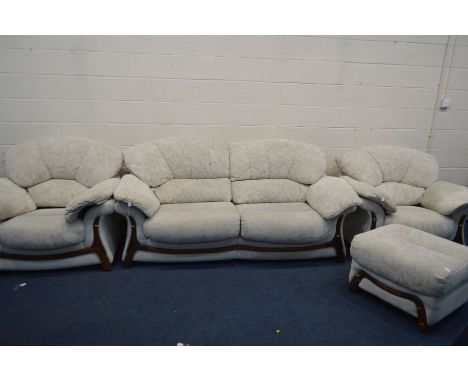 A CREAM UPHOLSTERED FOUR PIECE LOUNGE SUITE, comprising a two seater settee, pair of armchairs and a pouffe (missing foot to 