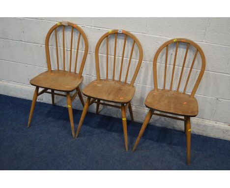 A SET OF THREE DISTRESSED ERCOL BLOND ELM AND BEECH HOOP SPINDLE BACK CHAIRS