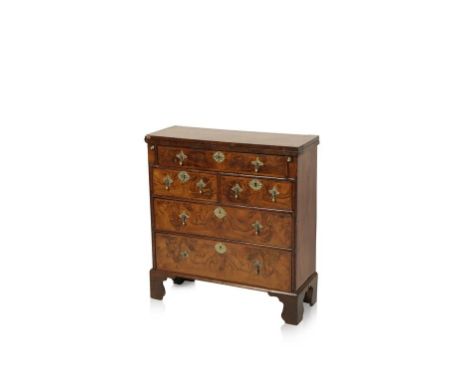 A GEORGE I WALNUT AND FEATHER BANDED BACHELORS CHEST, the fold-over top enclosing an inset writing surface above a frieze fit