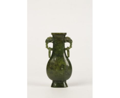 A CHINESE SPINACH JADE VASE, of flattened baluster form with twin rams mask loop handles, 11cms high