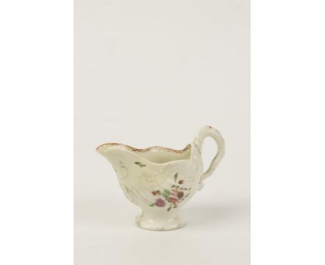 A FIRST PERIOD WORCESTER "DOLPHIN EWER" CREAM JUG, the moulded body on a pedestal foot, painted with sparse sprays of polychr