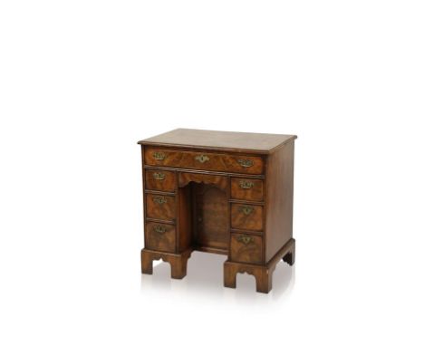 A GEORGE I WALNUT AND FEATHER BANDED KNEEHOLE DESK, the moulded top above a frieze drawer and three further short drawers, fl