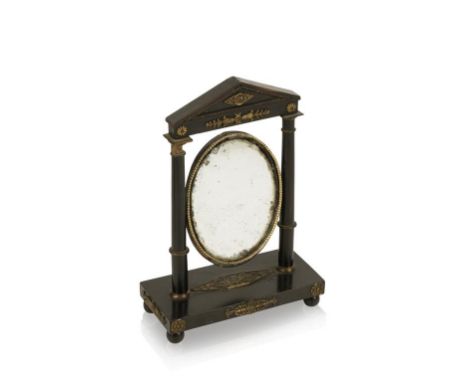 A GERMAN EMPIRE STYLE EBONISED AND GILT METAL OVAL MOUSTACHE MIRROR of architectural form with column beneath a triangular pe