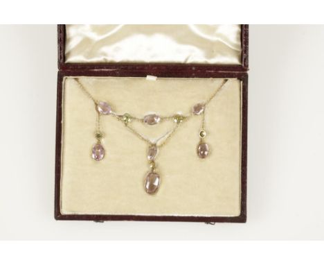 A PINK TOPAZ, PERIDOT AND DIAMOND NECKLACE, the seven graduating oval-cut pink topaz interspersed with four graduated peridot