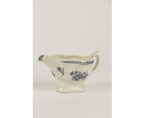 A FIRST PERIOD WORCESTER PORCELAIN SAUCEBOAT, the moulded body painted in blue with floral decoration, on an oval raised foot