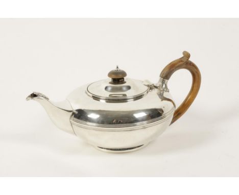 A WILLIAM IV SILVER TEAPOT of compressed circular form, wooden scroll handle, reeded girdle, crested on a circular tucked in 