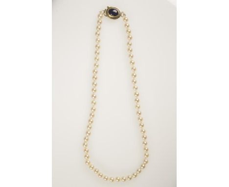 A CULTURED PEARL NECKLACE, each pearl knotted and terminating in a 9ct yellow gold clasp set with a dark blue oval opal, c.56