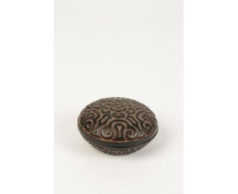 A CHINESE 'TIXI' LACQUER SEAL PASTE BOX, the sides carved through layers of black and red with ruyi scrolls, 7 1/2cms diam.