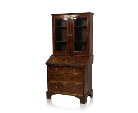 A GEORGE I WALNUT AND FEATHER BANDED BUREAU BOOKCASE, the moulded cornice above two glazed panel doors enclosing shelves, the