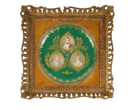 A SEVRES PORCELAIN CHARGER painted with three portraits of Napoleon Bonaparte, his wife and son, within gilt borders on green