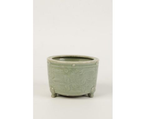 A CHINESE CELADAON GLAZE TRIPOD CENSER, the sides with incised decoration, Ming dynasty, 15cms diam