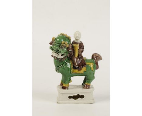 A CHINESE SANCAI GLAZE FIGURAL JOSS STICK HOLDER, modelled as a figure seated on a kylin, pierced pedestal base, Qing dynasty