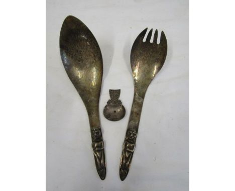 A silver caddy spoon and 2 plated Haida design salad servers