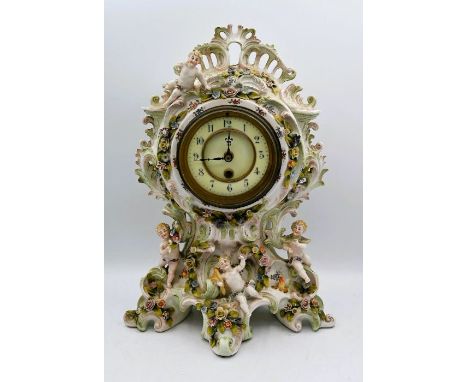 A Porcelain Mantle Clock decorated with Applied Bocage Flower and Cherubs Raised on Scrolled Feet Hand Painted glazed, the or