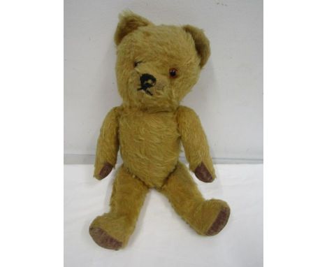 A vintage teddy bear with moveable arms and legs