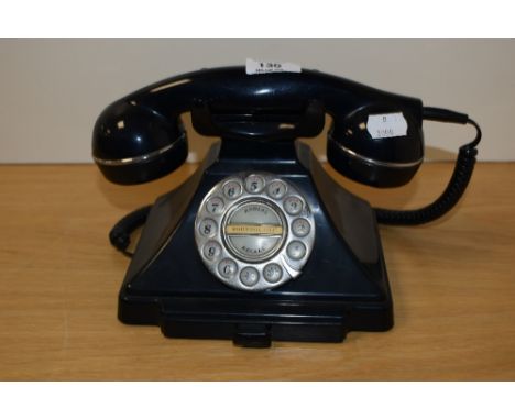 A vintage bakelite rotary dial telephone in black, measuring 15cm tall