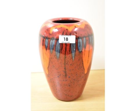A vintage Poole Pottery vase, having red, orange and blue glaze.