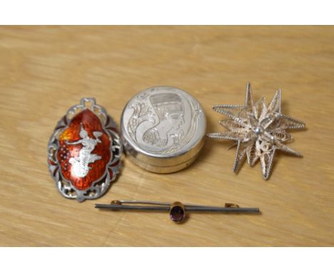 A collection of silver brooches including one of a filigree starburst design and a Thai red enamel brooch depicting a figure 