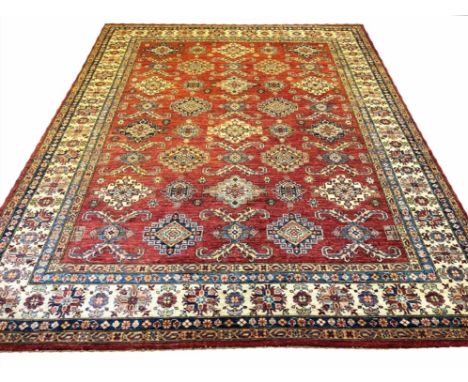 FINE KAZAK CARPET, 312cm x 244cm, all over repeat geometric medallions on a ruby field within corresponding bands and borders