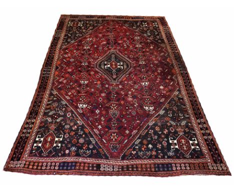 QASHQAI RUG, 255cm x 170cm, central medallion on a ruby field of stylised motifs within complimentary spandrals and borders. 