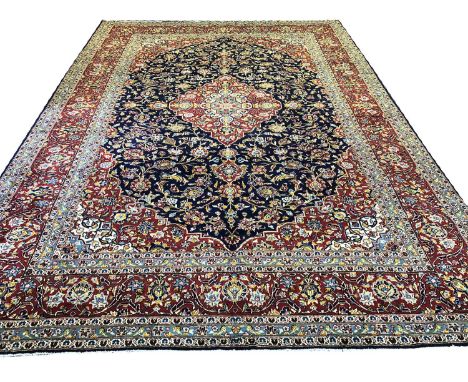 FINE KASHAN CARPET, 420cm x 300cm, central medallion on a palmette and vine sapphire field within a complimentary spandrels a