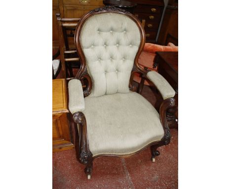 A Victorian walnut button upholstered open armchair