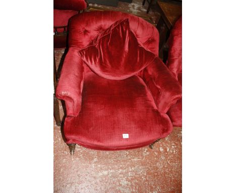 A late Victorian red upholstered button back armchair with turned legs
