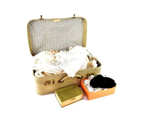 A vintage faux snakeskin suitcase containing a quantity of late Victorian and early 20th century lace, crochet work and other
