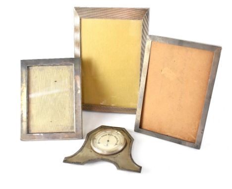 Two hallmarked silver photograph frames, one other white metal photograph frame and a small desk barometer in a hallmarked si