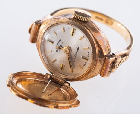 A Rotary watch ring, a 9ct yellow gold ring with a mechanical rotary watch face, hidden underneath a hinged flower shaped cov