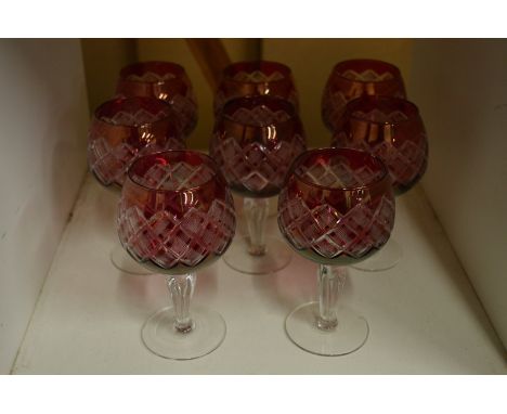 A set of eight ruby tinted cut glass wine glasses.
