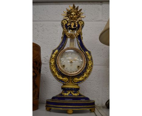 A decorative lyra shaped mantel clock.