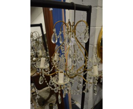 A decorative six branch glass and bronze metal chandelier.