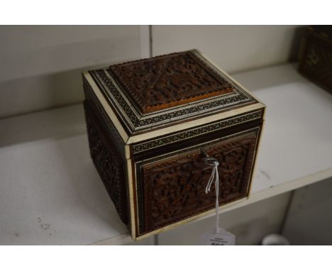 An Eastern carved sandalwood and inlaid tea caddy.